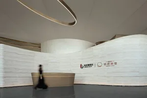 A minimalist lobby interior with curved marble walls and a reception desk.