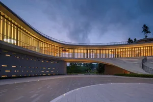Modern building with illuminated glass walls at dusk
