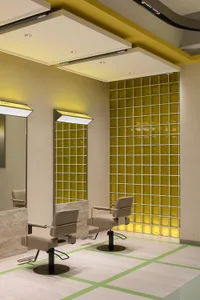 Modern interior design of a hair salon featuring glass tiles and leather chairs.