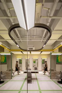A modern hair salon interior with clean lines, contemporary lighting, and green accents.