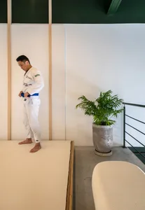一間工業風辦公空間，採用極簡設計，搭配混凝土地板與牆面，以及一盆置於混凝土花盆中的植栽