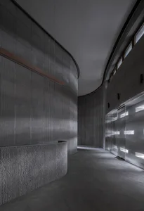 Modern interior space featuring concrete materials and curved walls.