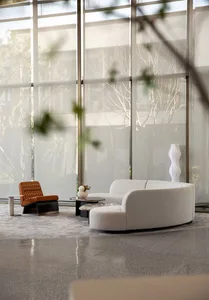 A modern lobby with terrazzo flooring and a white sofa with a coffee table.