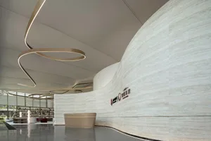 A modern lobby with a marble wall and circular lighting fixture