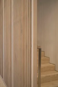 Modern minimalist wooden staircase with vertical slats and metallic handrail
