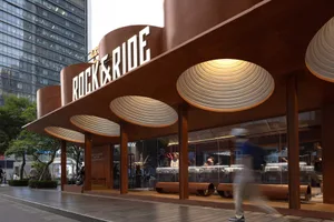 Modern storefront with a metal canopy and circular lighting.