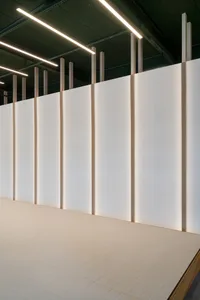 Minimalist installation art featuring a white fabric wall with light strips