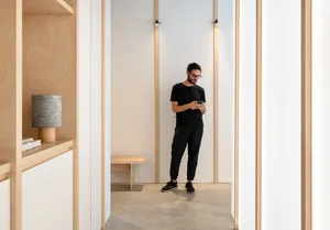Minimalist, white-walled room featuring concrete flooring and a single wooden bench.