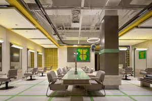 Industrial-style hairstylist salon with concrete walls, glass partitions, and metal accents.