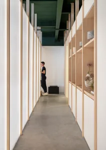 Minimalist corridor with concrete flooring and wooden shelving.