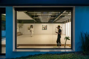 Modern minimalist training space with white walls, artwork, and tiled floor.