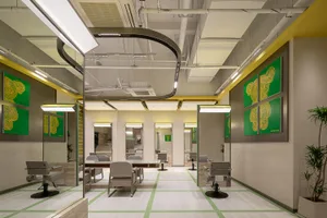 Modern minimalist salon interior with white walls and green accents, featuring sleek and contemporary furniture.