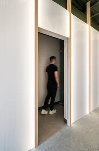 A modern office space featuring white walls clad in sandwich panels