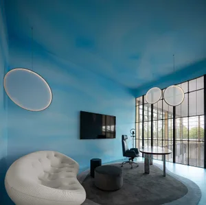 A modern office space featuring glass walls with minimalist interior design.