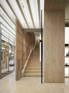 A modern retail storefront featuring wood, concrete, and metallic elements.