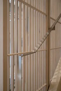 Modern staircase with wooden vertical panels and metal handrails.