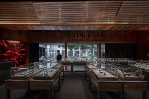 A modern retail jewelry shop featuring glass showcases, wooden displays, and illuminated signage.