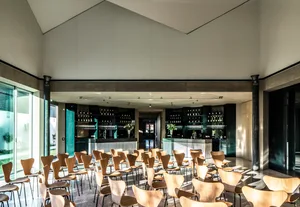 A modern conference room with wooden chairs and concrete walls.