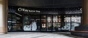 A modern minimalist storefront with large glass windows and metal accents.