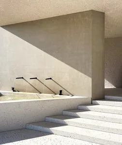 A minimalist outdoor water fountain with concrete and terrazzo materials.