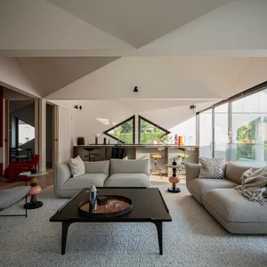 Modern living room featuring grey sofas, textured cushions, and a dark wooden coffee table.
