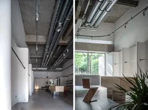 A modern lobby with concrete walls and ceiling, featuring a minimalist design.