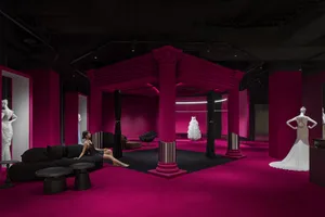 A stylish, fuchsia-themed fashion exhibition space with elegant designs and furniture.