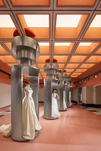 Modern retail store featuring metallic cylindrical columns, glass panels, and concrete flooring.
