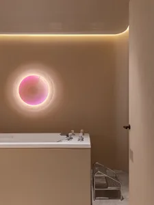 A minimalist bathroom with a round window and plaster walls.