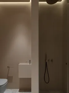 A minimalist bathroom with tiled walls, modern fixtures, and a sleek design.