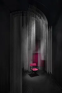A minimalist interior design featuring metallic chains as a decor element.