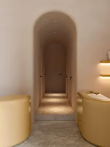 A modern corridor with a curved ceiling and smooth concrete floor and walls.
