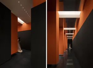 現代室內設計，深色牆面搭配橙色燈具。