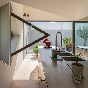 A modern residential kitchen featuring wooden finishes and a sleek, contemporary design.