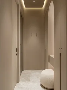 Minimalist corner wardrobe with neutral-toned materials and a cushioned seat.