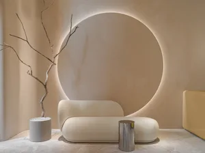 A modern living room with textured fabric furniture, concrete floor, and metal accents.