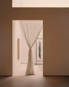 A minimalist clothing store with a white curtain covering the opening.