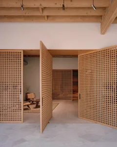 Open wooden lattice doors leading into a minimalist interior design space.