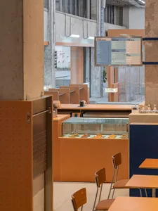An industrial-style cafe interior with concrete walls and modern furnishings.