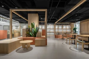An elegant, minimalist cafe interior with warm wood elements and green plants, featuring comfortable seating arrangements and