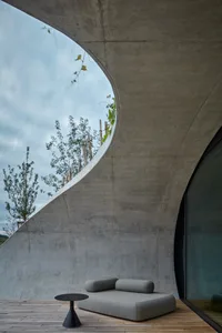 Contemporary interior design featuring modern furniture and minimalist aesthetic, primarily constructed with concrete materia