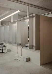 A modern hair salon interior with concrete walls and minimalist design.
