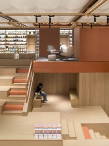 A modern library or bookstore interior with wooden materials and open seating areas.
