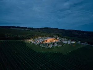A modern wine tasting room with stone, glass, and wooden elements.