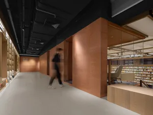 A modern industrial library with wooden walls and shelves filled with books.