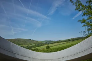 Concrete walkway overlooking scenic green hills with clear blue sky