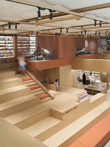 Modern bookstore interior with wooden shelves, glass partitions, and seating areas.