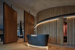Modern lobby interior with wooden, concrete, and metallic reception desk.