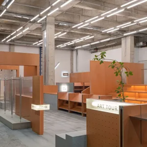 Modern retail space featuring a minimalist design with concrete and orange materials.