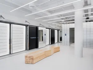 A modern retail shop with a minimalist design featuring wooden elements and white surfaces.